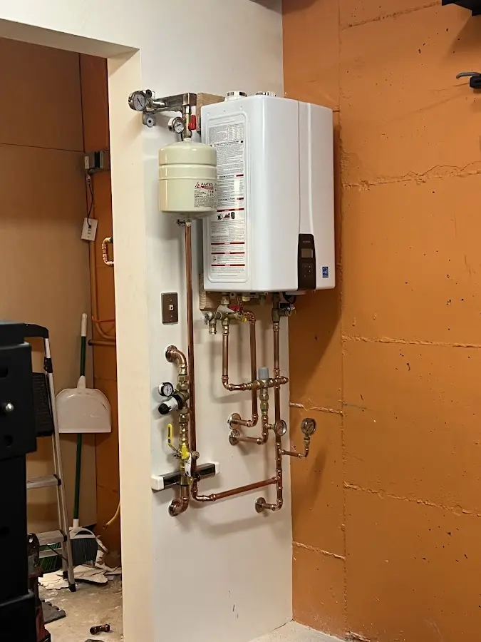 Plumbing technician inspecting water heater connections in Golden Hills